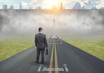 A difficult road to success. A man with a briefcase in his hand in front of an obstacle.