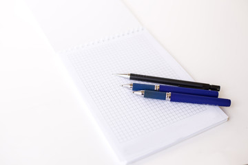 notebook in line with empty place  and  pencil on the white background (vertically)