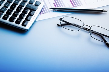 Calculator, Pen, Glasses And Financial Report On Desk Close-up