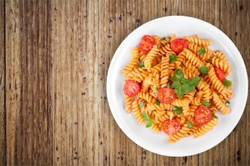 Spaghetti pasta with tomatoes and parsley on  table.