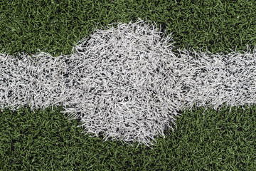 Soccer field with artificial grass, lines to mark the lawn and selective focus on part of the grass