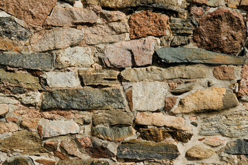 Wall of various stones close-up of different colors and shades of background and testures