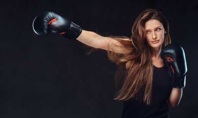 Beautiful brunette female boxer during boxing exercises, focused on a process with serious...