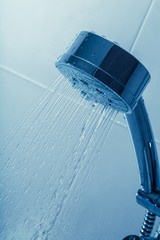 Naklejka na ściany i meble Shower Head with Water Stream on Blue Background