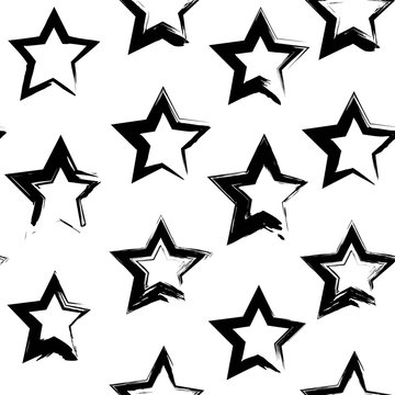 Seamless pattern from abstract black star shape textured smears  on a white background