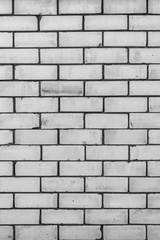 texture of a wall from a natural white brick with small cracks and chips, close-up abstract background