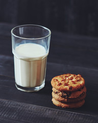Homemade oatmeal biscuits with peanut and glass of milk on a textile background - traditional Christmas treat for Santa.