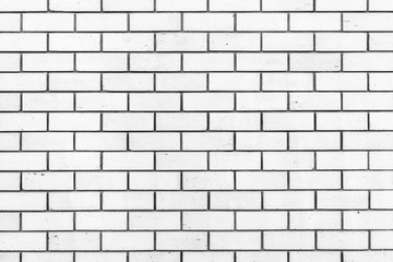 texture of a wall from a natural white brick with small cracks and chips, close-up abstract background