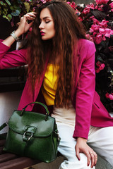Outdoor fashion portrait of young beautiful woman wearing trendy fuchsia color blazer, wrist watch,...