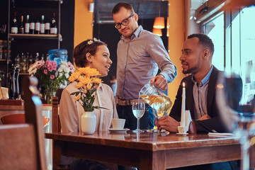 Happy attractive African-American couple in love having a great time together in a restaurant at their dating. A beautiful couple enjoying each other.