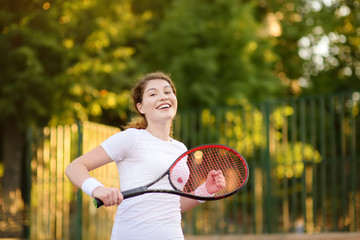 Young female tennis player with tennis ball and racket preparing to serve
