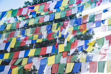 Tibetan prayer flags or colorful Buddhist prayer flags hanging in Kathmandu, Nepal to send prayers and messages in the wind for peace, health, luck, wisdom, happiness and prosperity