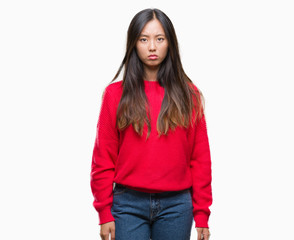 Young asian woman wearing winter sweater over isolated background skeptic and nervous, frowning upset because of problem. Negative person.