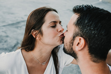 Fototapeta premium .Young and beautiful couple in love enjoying an afternoon outdoors near the port of Gijón, in Asturias (Spain). A fun and playful couple. Love. Lifestyle.