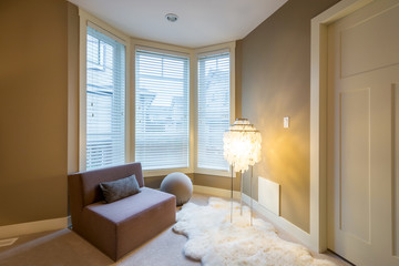 Fragment of a modern luxury master bedroom with a large chair , lamp, and a sheepskin rug. Interior design.