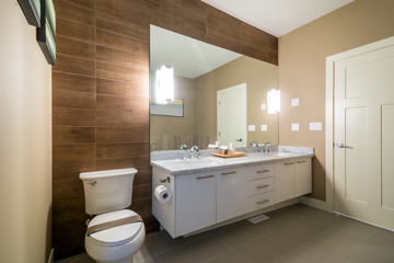 Fototapeta na wymiar Interior design of a luxury bathroom with a wood wall and a large mirror.
