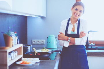 Young woman standing near desk in the kitchen