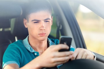 Portrait of a Young Man Texting While Driving