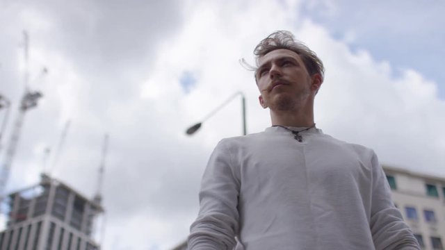 Portrait of male parkour athlete standing in the city, in slow motion