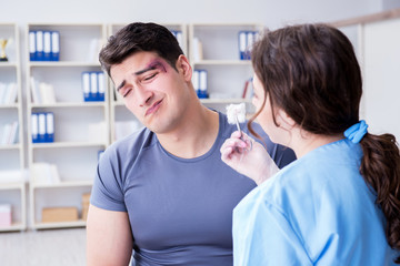 Obraz premium Young man visiting female traumatologist with black eye 