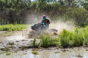 ATV Quad rides fast on big dirt and makes splashes of dirty water © suvorovalex