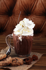 A messy cup with hot chocolate and chocolate chip cookies.