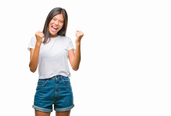 Obraz na płótnie Canvas Young asian woman over isolated background very happy and excited doing winner gesture with arms raised, smiling and screaming for success. Celebration concept.