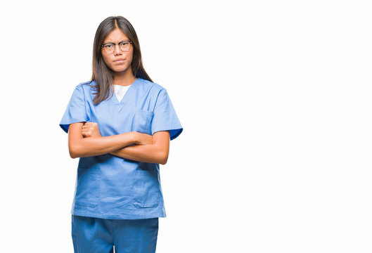 Young asian doctor woman over isolated background skeptic and nervous, disapproving expression on face with crossed arms. Negative person.