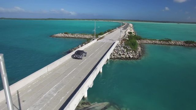 Car drives on coastal roadway in Turks and Caicos, aerial