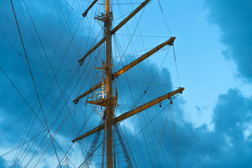 The mast of a large sailing ship against the background of the evening sky
