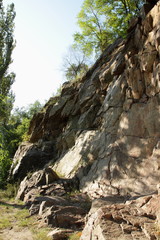 Fototapeta na wymiar Granite rocks in the sun. Texture of granite stone. Background of natural material. Rocky rocks of ancient times