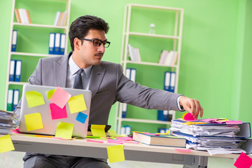 Businessman unhappy with many conflicting priorities sitting in 