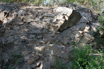 Fototapeta na wymiar Granite rocks in the sun. Texture of granite stone. Background of natural material. Rocky rocks of ancient times