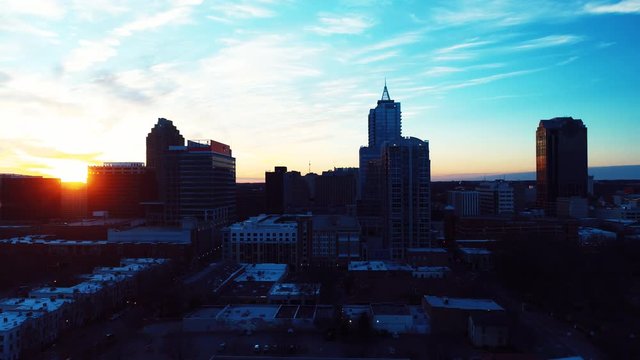 Panning aerial, sunset over Raleigh skyline