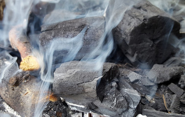 Smoke rising from charcoal used in cooking grill