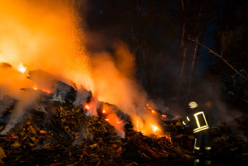 night fire in the forest and fireman in work
