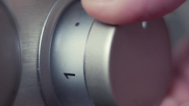 Male Fingers Turning Electric Stove Knob