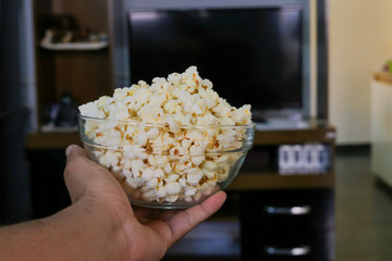 Close up man holding a bowl with popcorn