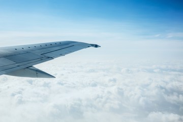 Airplane Wing Out of Window with Clouds and Sky