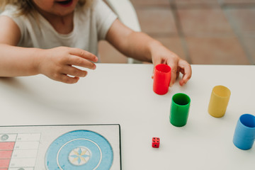 Manos de niña jugando al parchis