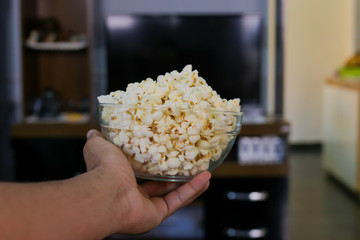 Close up man holding a bowl with popcorn