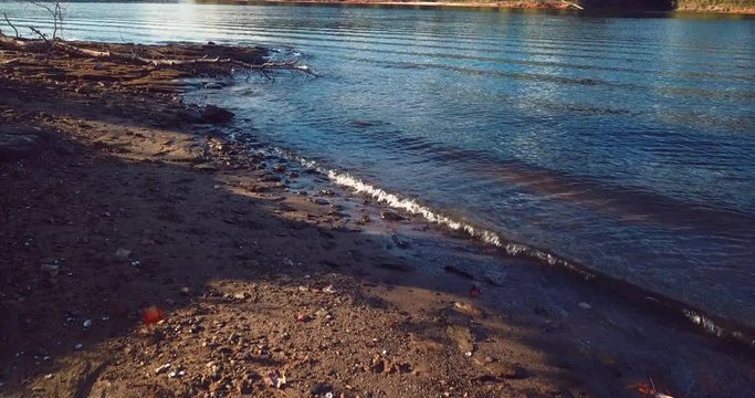 Tilt up aerial, lake waves on shore
