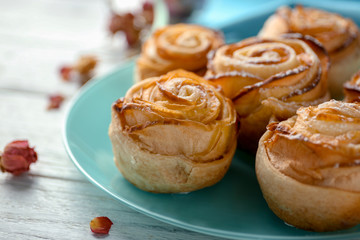 Plate with apple roses from puff pastry on table, closeup