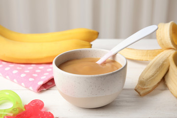 Bowl of healthy baby food on wooden table