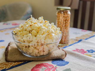 glass bowl with popcorn and corn seeds