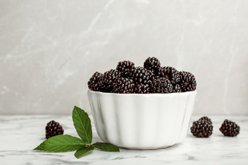 Fototapeta na wymiar Bowl of fresh blackberry on marble table