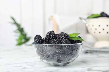 Bowl with fresh blackberry on marble table