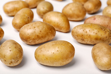 Fototapeta na wymiar Fresh organic potatoes on white background, closeup view