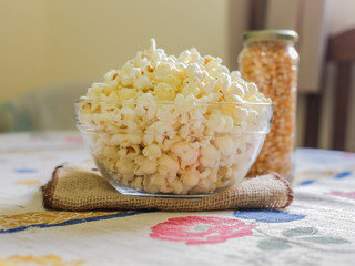 glass bowl with popcorn and corn seeds