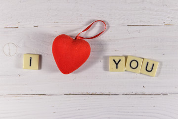 Red hearts and "I Love You" text on white wooden background